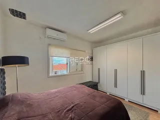 Quarto com armários embutidos e janela na sala.