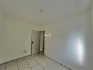 Hall de entrada com paredes brancas e piso cerâmico.