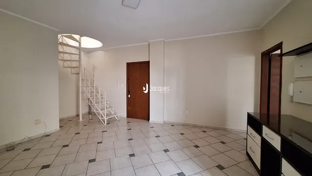 A sala de estar apresenta um piso de cerâmica e uma escada branca.