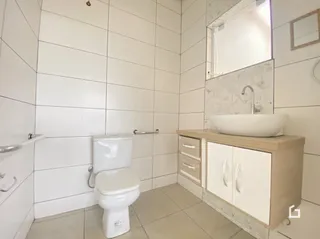 Foto de um banheiro com revestimento cerâmico branco.