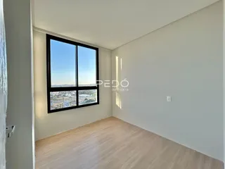 Sala de estar com grande janela de vista para a paisagem urbana.