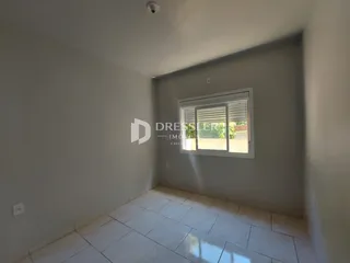 Hall de entrada com piso de cerâmica clara e paredes cinzas.