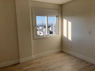 Vista interna de um cômodo com piso de madeira e janela.