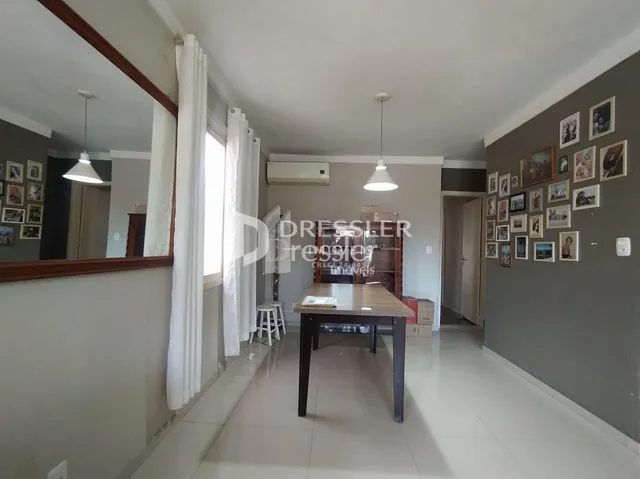 Vista interna de um corredor com paredes brancas e piso claro.