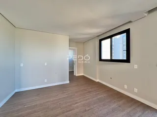 Ambiente interno com piso de madeira e parede branca.