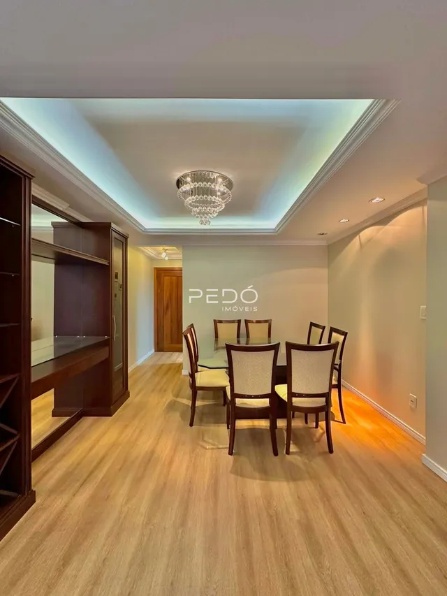 Ambiente interno com piso de madeira e mesa de jantar em um imóvel.