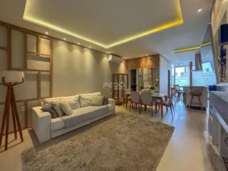 Sala de estar moderna com sofá e área de jantar em um imóvel no Brasil.