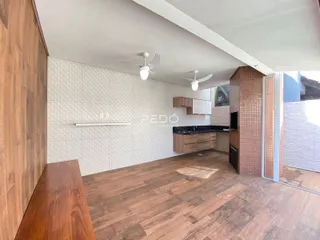 Ambiente interno de uma sala de estar com piso de madeira e parede de azulejos em Lajeado, Brasil.