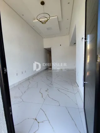 Um corredor interno de uma residência com piso de mármore claro.