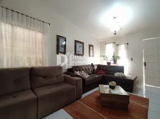Sala de estar com sofá e piso de madeira em um imóvel no Brasil.