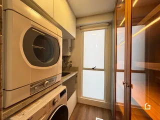 Foto de uma cozinha com eletrodomésticos e armários brancos.