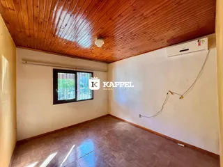 Esta é uma sala com piso de madeira e teto de madeira exposto.