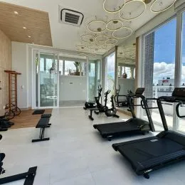 Foto de uma área de ginástica interna com equipamentos de cardio.