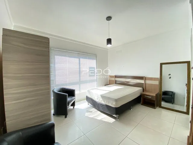 Quarto com cama, guarda-roupa e piso de cerâmica em um imóvel.