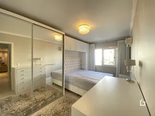 Quarto com cama e paredes brancas.