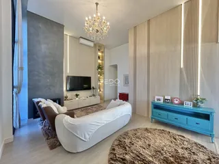 Sala de estar moderna com sofá branco e decoração clara.