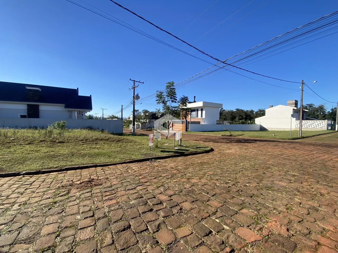 Vista externa de uma propriedade com jardim e área pavimentada.