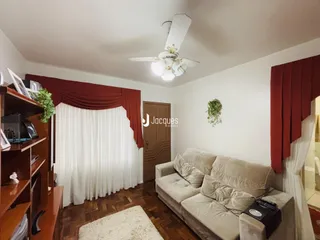 Sala de estar com sofá e cortinas vermelhas.