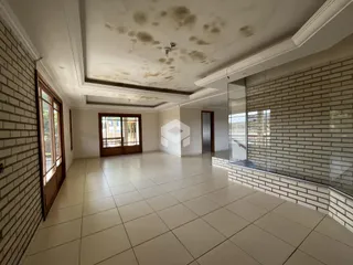 Sala de estar com piso de cerâmica clara e parede de tijolos expostos.
