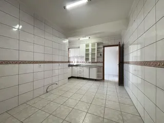 Hall de corredor com piso de cerâmica e paredes de azulejo.