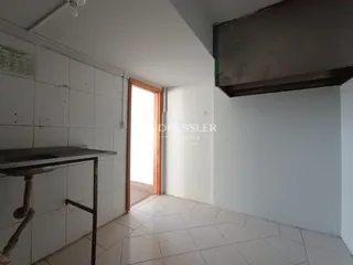 Hall de entrada com piso de cerâmica branca e paredes brancas.