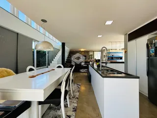 Ambiente aberto com mesa de jantar e cozinha moderna em um imóvel.