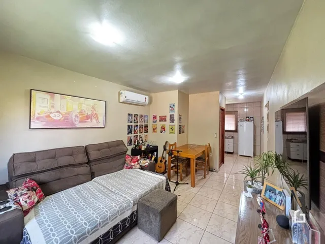 Ambiente interno de uma sala com sofá e cama em um imóvel no Brasil.