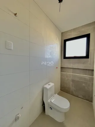 Foto de um banheiro com paredes brancas e piso claro.