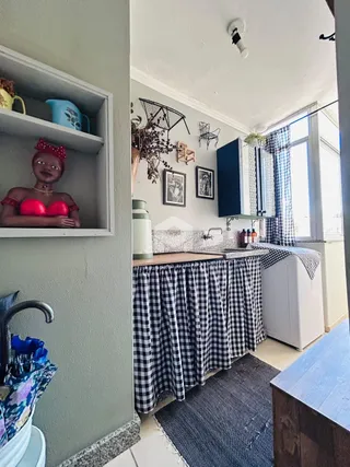 A cozinha apresenta uma bancada com um tecido xadrez sobre ela.