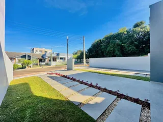 Foto da fachada de uma residência em Lajeado, Brasil, com jardim e área pavimentada.