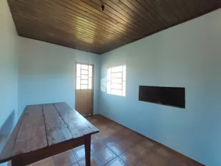 Interior de uma sala com teto de madeira e piso de madeira.