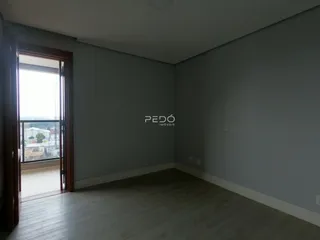 Ambiente interno de uma sala com piso de madeira e parede cinza claro.