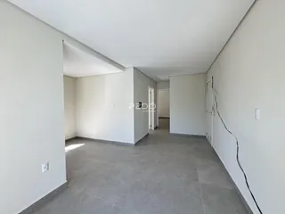 Hall de entrada com paredes brancas e piso cinza.