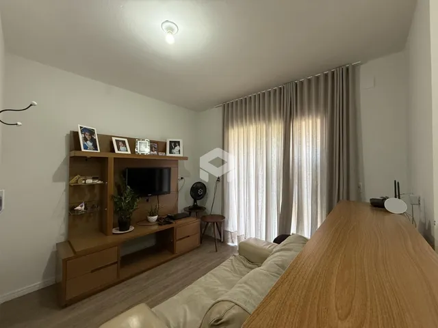 Sala de estar com decoração de madeira e cortinas claras.