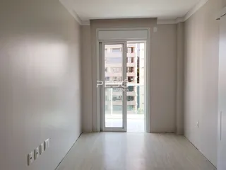 Hall de entrada com piso de madeira clara e porta de vidro que dá para a vista externa.