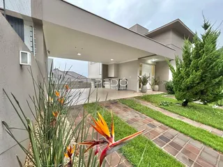 Vista externa de uma residência moderna com jardim e paisagismo.