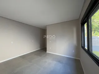 Vista interna de um corredor com paredes claras e piso de cerâmica.