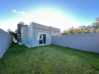 Fachada de uma casa em Lajeado, Brasil, com jardim gramado e muro lateral.