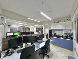 Foto de um escritório moderno com mesas de trabalho e armários em um imóvel no Brasil.
