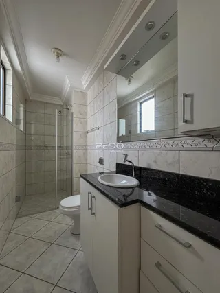Foto de um banheiro com revestimentos de cerâmica e bancada escura.