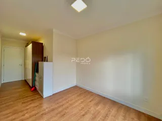 Ambiente interno com piso de madeira e paredes brancas.
