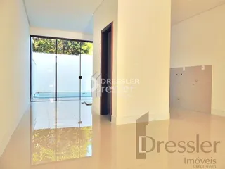 Um cômodo interno com portas de vidro se abre para uma área externa.