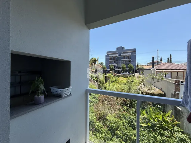 Vista da propriedade com jardim exuberante ao fundo.