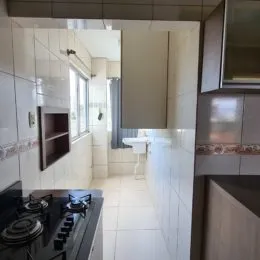 Corredor interno com piso de cerâmica e paredes claras.