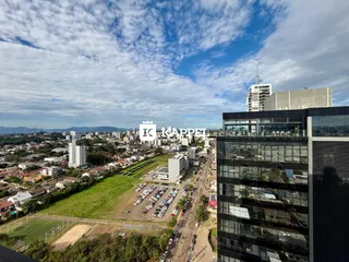 Vista aérea de uma área urbana com um grande campo verde e edifícios modernos.