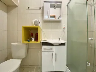 Foto de um banheiro interno com azulejos brancos e box de vidro.