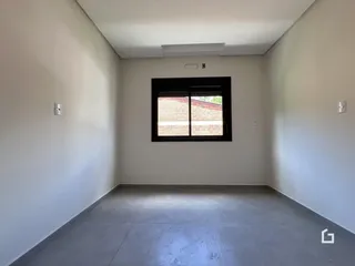 Foto de um ambiente interno com paredes brancas e uma grande janela.