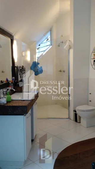 Foto de um corredor interno com paredes brancas e um espelho.