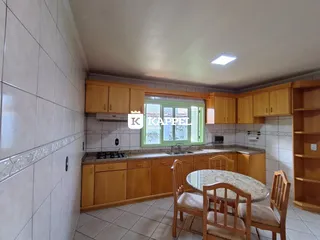 Foto de uma cozinha com armários de madeira e mesa de jantar.