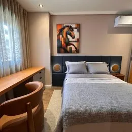 Foto de um quarto com cama e mesa de madeira.